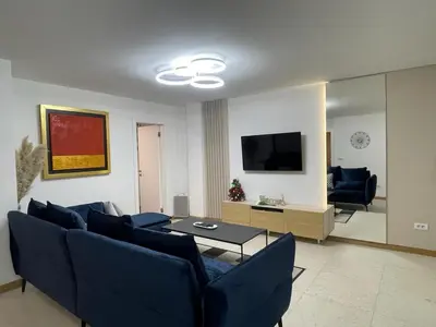a living room with a blue couch and a tv at NBG113 apartment in Belgrade