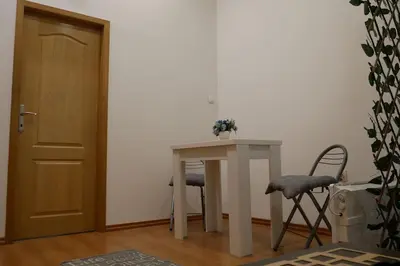 a table and chairs in a room with a door at Cozy place in Belgrade