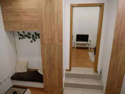 a room with a bed and a door to a living room at Cozy place in Belgrade