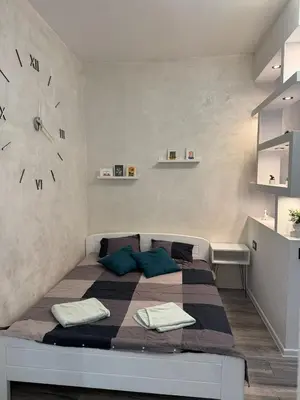a bedroom with a bed with a large clock on the wall at M&L downtown apartment in Sajmište