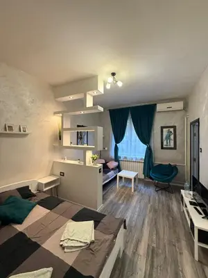 a bedroom with a bed and a desk and a chair at M&L downtown apartment in Sajmište