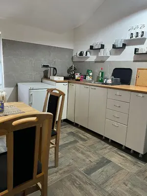 a kitchen with white cabinets and a table and chairs at Old town Belgrade apartment in Belgrade