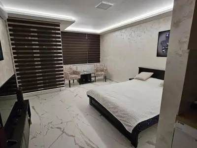 a bedroom with a bed and a table and chairs at Stan na dan Jovanovic in Kneževac