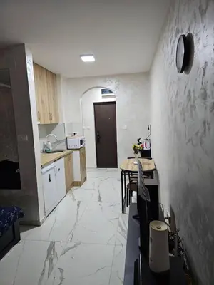 a kitchen with a large tile floor and a table at Stan na dan Jovanovic in Kneževac