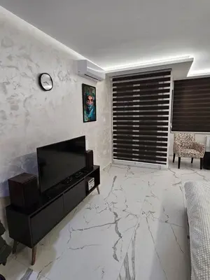 a living room with a television on a marble floor at Stan na dan Jovanovic in Kneževac
