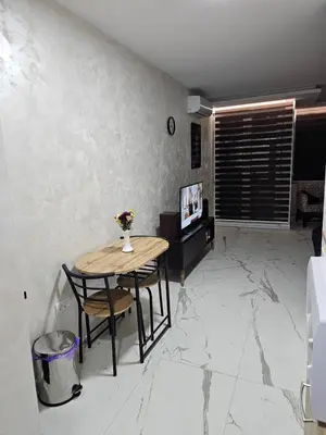 a table and chairs in a room with marble floors at Stan na dan Jovanovic in Kneževac