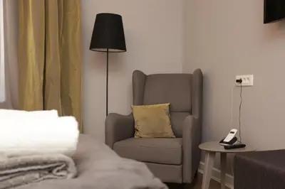 a living room with a chair and a lamp at Moment Boutique Apartments in Belgrade