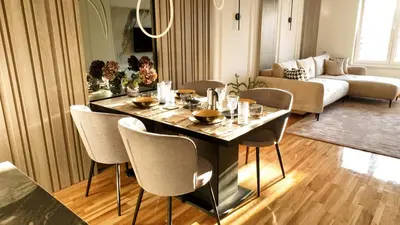 a dining room with a table and chairs in a living room at New&Luxurious, Central&Comfortable in Belgrade