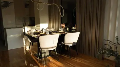 a dining room table with white chairs in a kitchen at New&Luxurious, Central&Comfortable in Belgrade