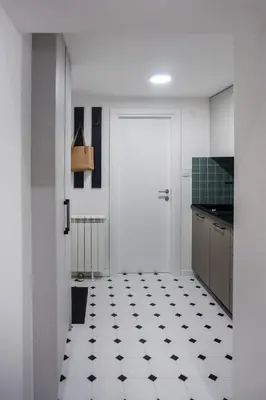 a kitchen with a white door and a black and white tiled floor at City life in Belgrade