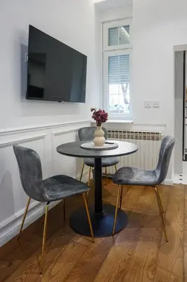 a table with two chairs and a tv on a wall at City life in Belgrade