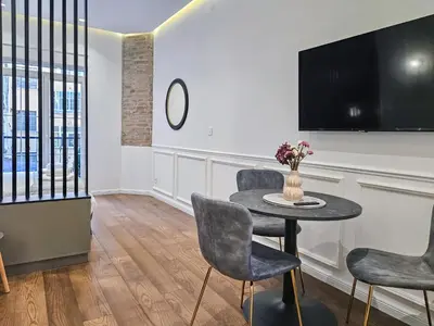a dining room with a table and chairs and a tv at City life in Belgrade