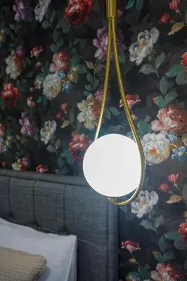 a lamp hanging from a wall with a floral wallpaper at City life in Belgrade