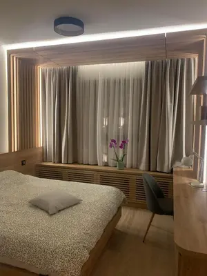 a bedroom with a bed and a window with purple flowers at BW Premium 5th Symphony in Belgrade
