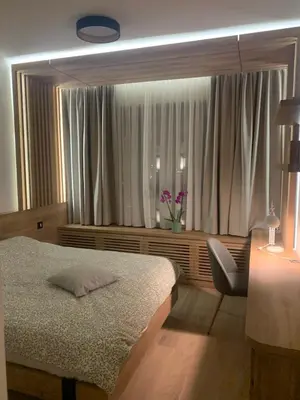a bedroom with a bed and a desk and a window at BW Premium 5th Symphony in Belgrade
