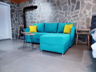 a blue couch with yellow pillows in a living room at Imanje in Arandjelovac