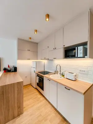 a kitchen with white cabinets and a sink at Sweet House Skadar Lux in Belgrade