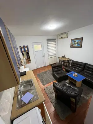 a living room with black leather furniture and a table at Apartment Dida Ledine in Belgrade