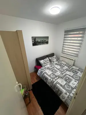 a small bedroom with a bed and a window at Apartment Dida Ledine in Belgrade