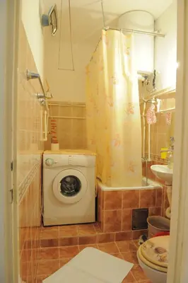 a bathroom with a washing machine and a shower at Apartment Daca Stan na dan in Belgrade