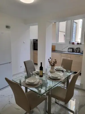 a dining room table with chairs and a bottle of wine at Slavija Lux! 2 Bedroom Apartment city center in Belgrade
