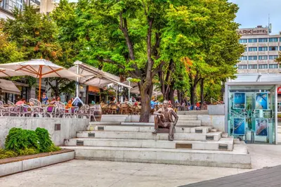 a statue sitting on some stairs in a park at Slavija Lux! 2 Bedroom Apartment city center in Belgrade