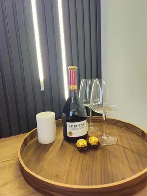 a bottle of wine on a wooden table with glasses at Dimiant Lux River BW in Sajmište