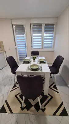 a dining room with a white table and chairs at Apartman Enjoy Arandjelovac in Arandjelovac