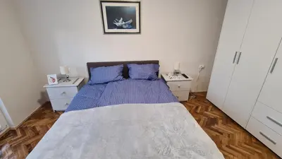 a bedroom with a large bed with blue pillows at Apartman Enjoy Arandjelovac in Arandjelovac
