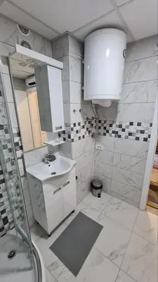 a white bathroom with a sink and a shower at Apartman Enjoy Arandjelovac in Arandjelovac