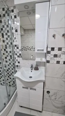 a white bathroom with a sink and a shower at Apartman Enjoy Arandjelovac in Arandjelovac