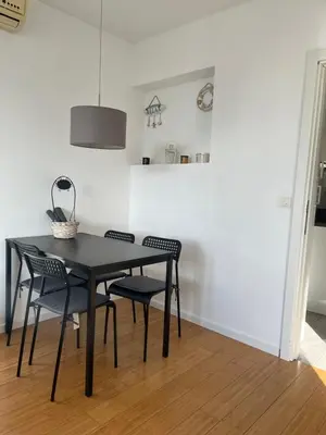 a dining room with a black table and chairs at Lenny apartman in Belgrade