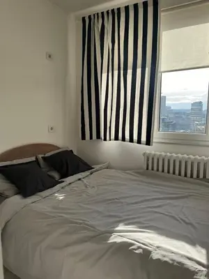 a large bed in a bedroom with a window at Lenny apartman in Belgrade