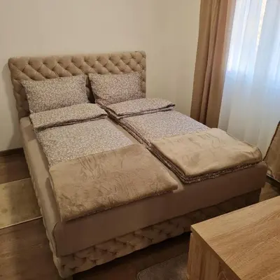 a bed with two pillows on it in a room at APARTMAN011 in Mirijevo