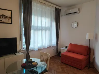 a living room with a red couch and a glass table at Parlament City Center in Belgrade