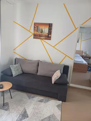a living room with a couch and a painting on the wall at Kućica LaMa-Кућица ЛаМа in Mali Mokri Lug