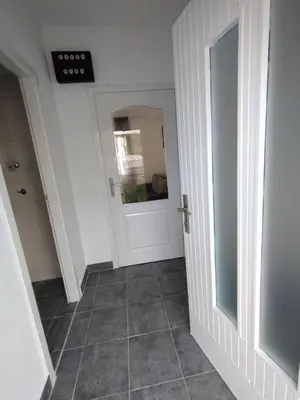 a hallway with a door and a tile floor at Kućica LaMa-Кућица ЛаМа in Mali Mokri Lug