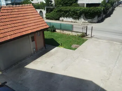 a small building with an orange roof next to a street at Kućica LaMa-Кућица ЛаМа in Mali Mokri Lug