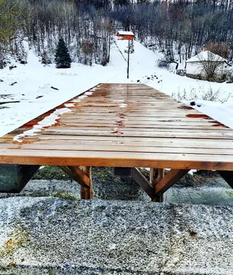 a wooden picnic table with snow on the ground at Brvnara in Arandjelovac