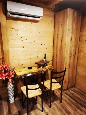 a wooden room with a table and two chairs at Brvnara in Arandjelovac