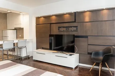 a bedroom with a large tv and a white cabinet at KAN Suites 1 in Belgrade