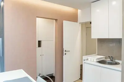 a kitchen with white cabinets and a sink at KAN Suites 1 in Belgrade