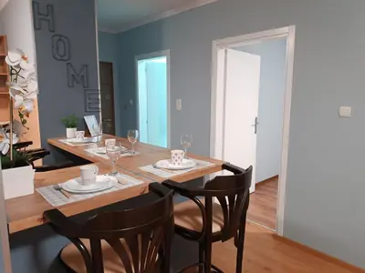 a dining room with a wooden table and chairs at Apartman Jela in Borča
