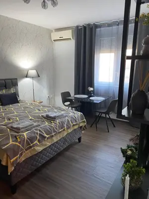a bedroom with a bed and a table and chairs at Apartman Felix in Zvezdara