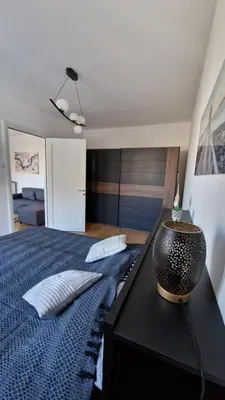a bedroom with a bed and a black table with a lamp at CashIN apartment in Belgrade