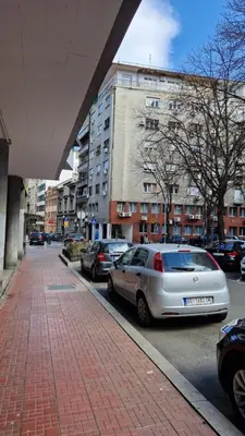 a city street with parked cars and buildings at CashIN apartment in Belgrade