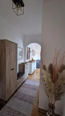 a kitchen with white walls and a vase with feathers at CashIN apartment in Belgrade