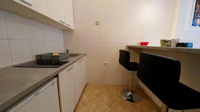 a kitchen with a table and a chair in it at Atos in Novi Beograd