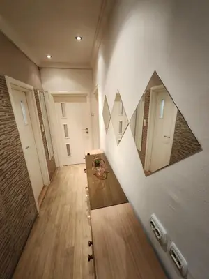 a hallway with two mirrors on the wall at Stadion apartman in Belgrade