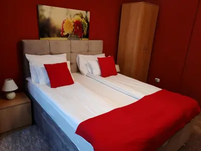 a bedroom with two beds with red and white pillows at Stadion apartman in Belgrade